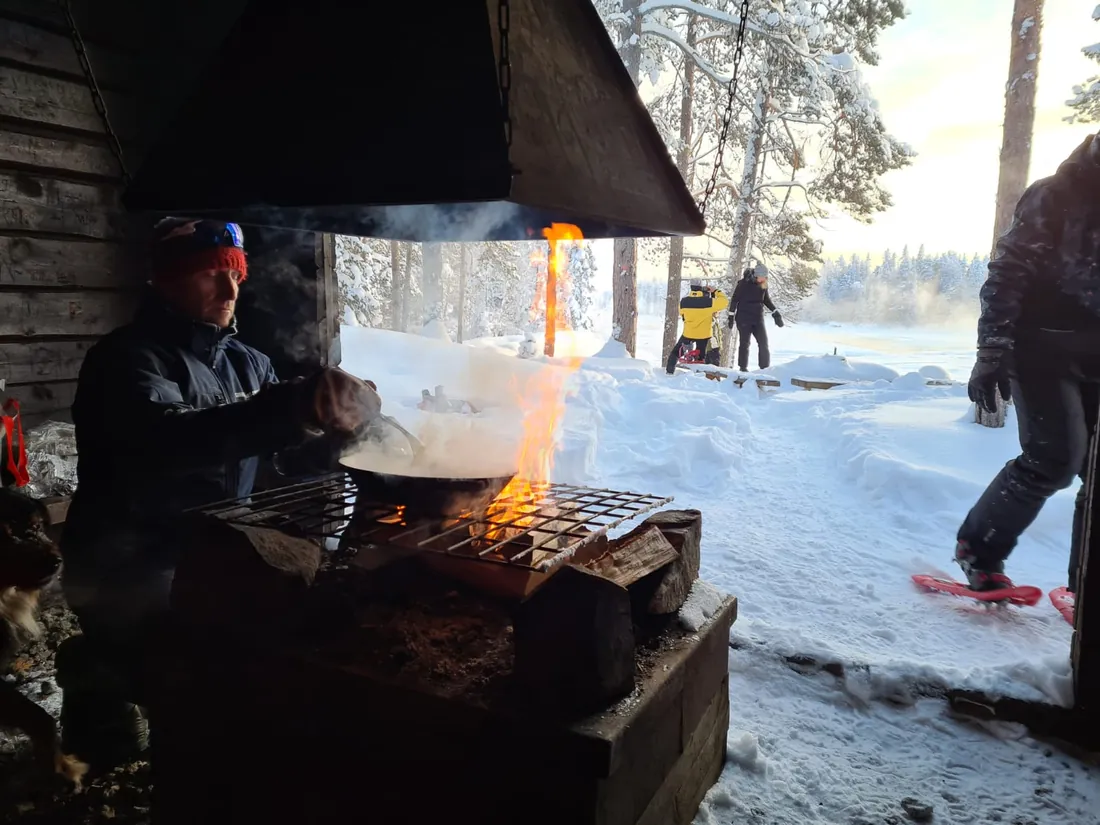 Cuisine et pain préparés au feu de bois, repas partagé en plein air dans la neige