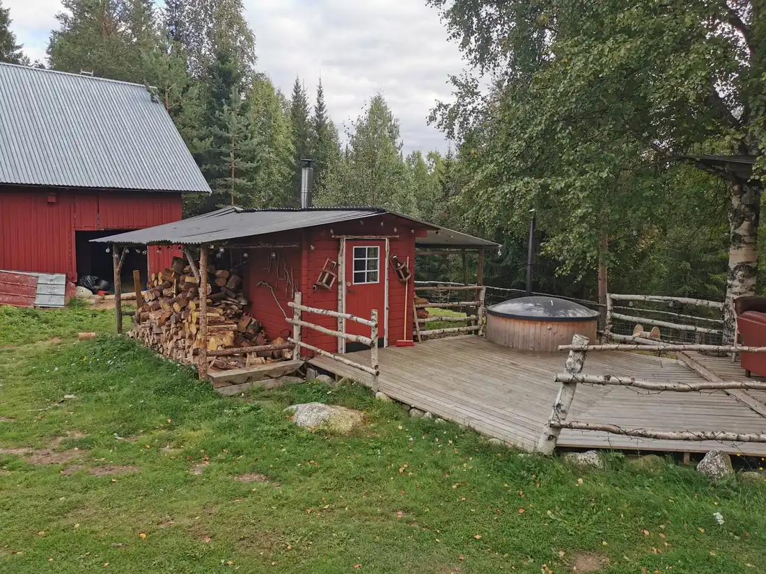 Chalet rouge avec terrasse et bain nordique en lisière de forêt