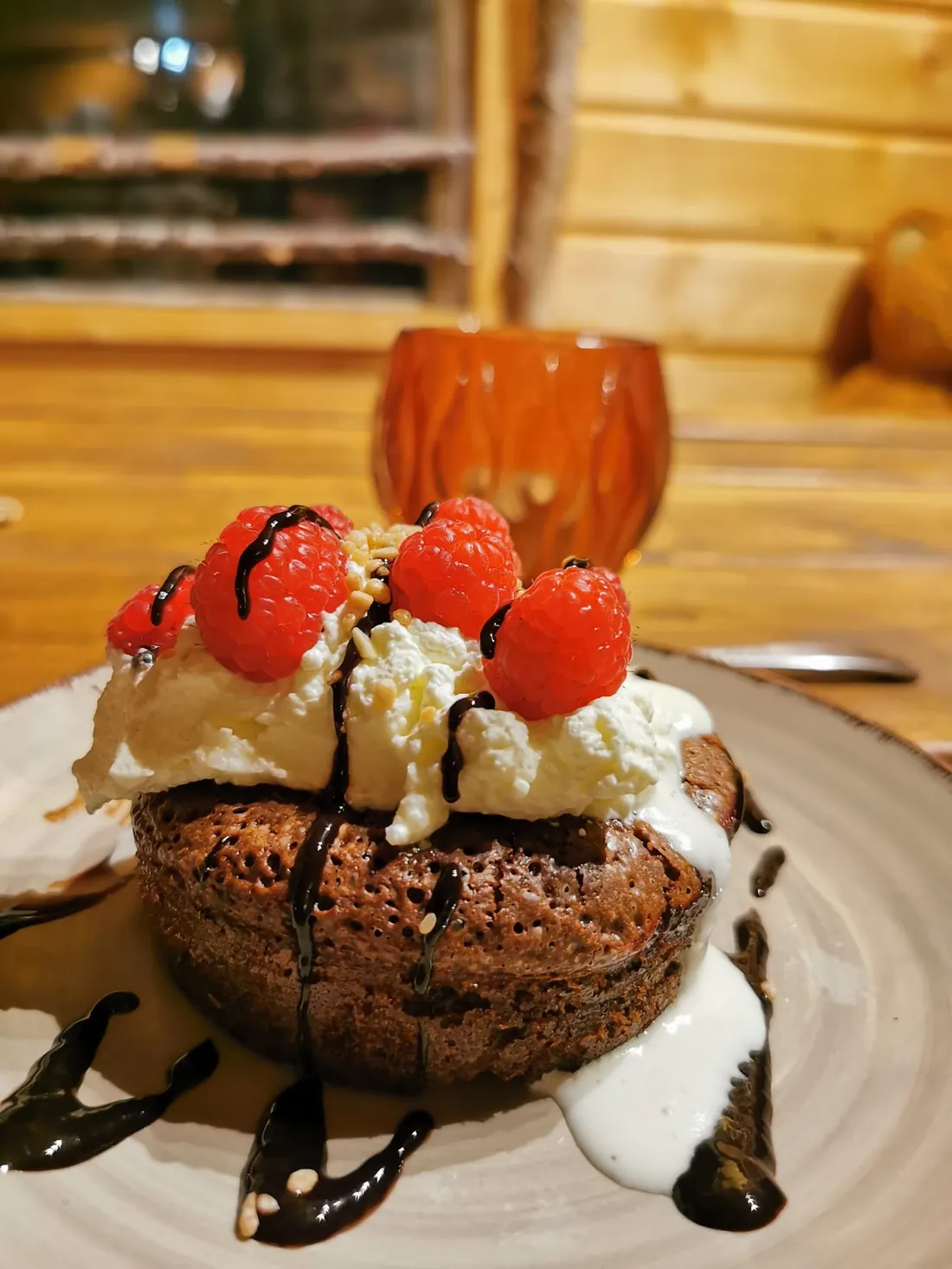 Dessert au chocolat garni de framboises et de chantilly, préparé maison au chalet