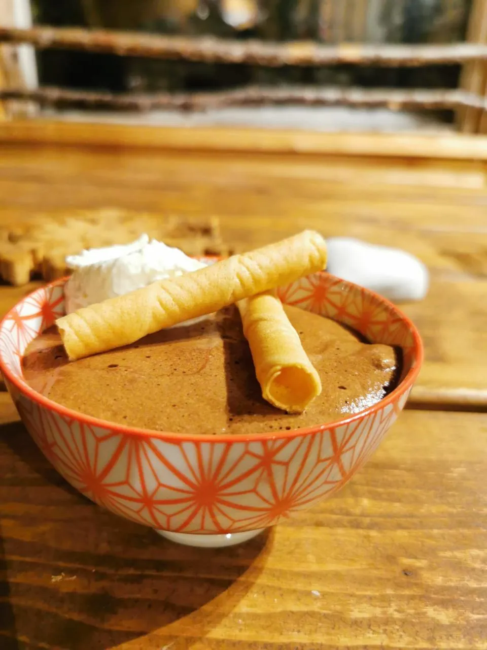 Mousse au chocolat maison, chantilly et cigarettes russes dans un bol en céramique