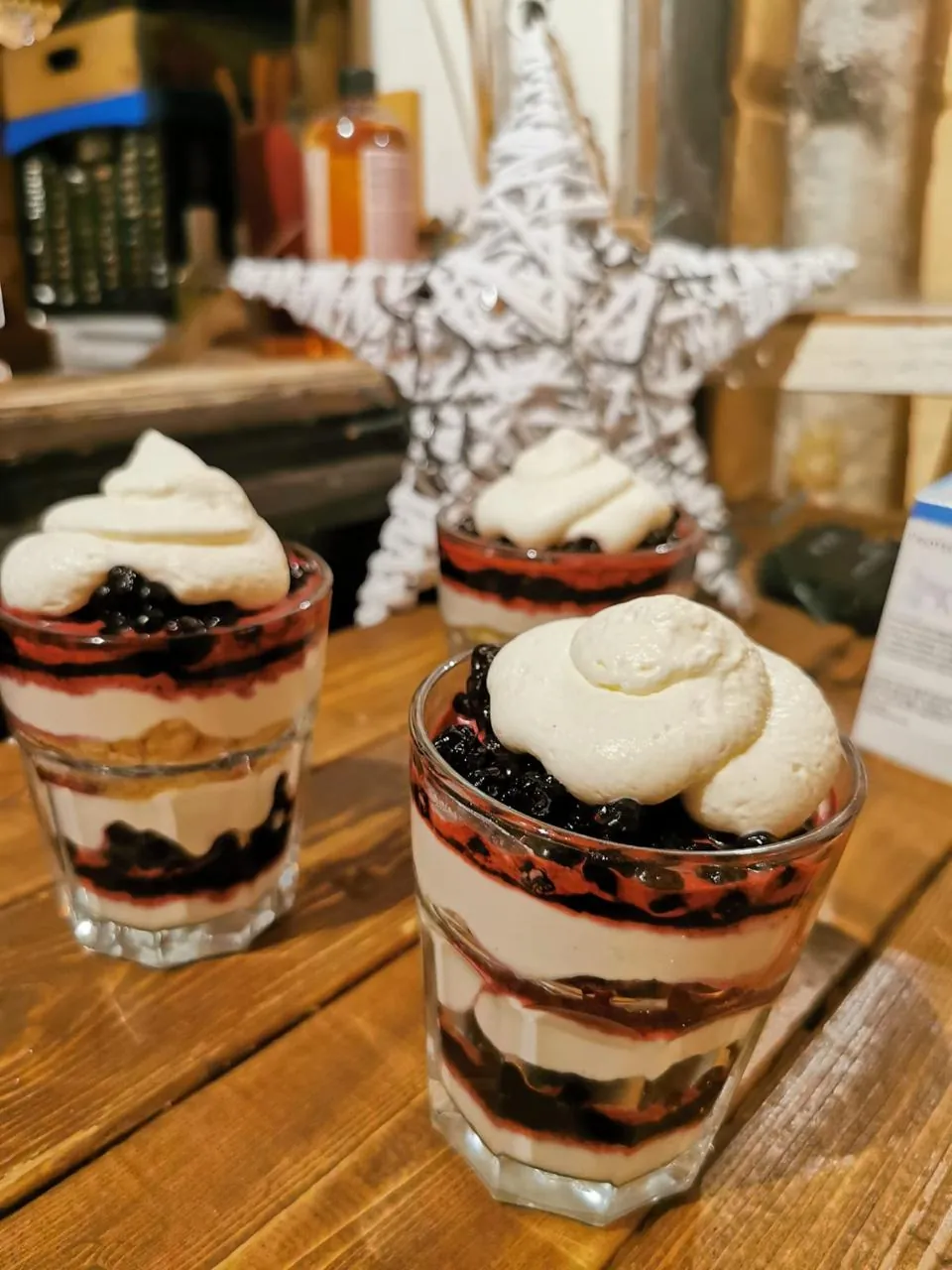 Verrines aux myrtilles et à la chantilly maison, dressées sur la table en bois