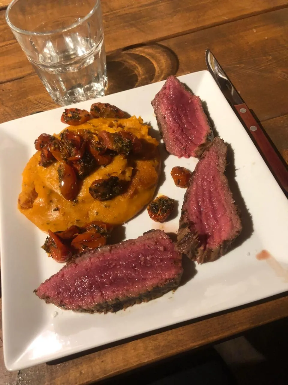 Pièce de bœuf rosée tranchée, écrasé de patate douce et tomates cerises confites